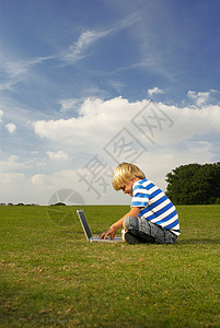 在野外玩计算机的小孩图片