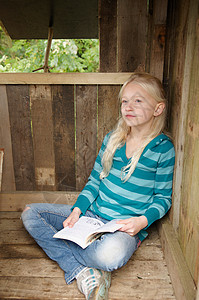 在树屋读书的年轻女孩图片