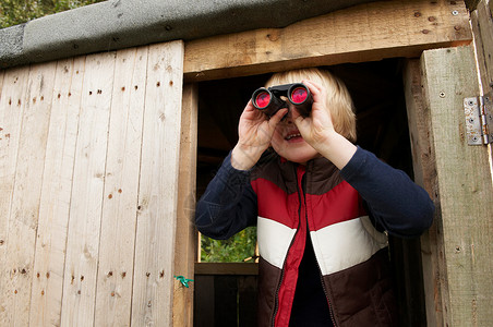 带着望远镜在树屋里的小男孩图片