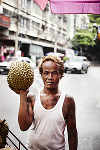 在街头卖榴莲果的人背景图片