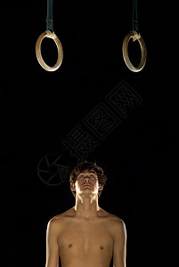 仰望吊环的体操运动员图片
