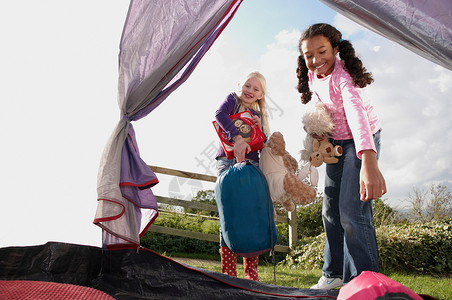 女孩们把睡袋放进帐篷里背景图片