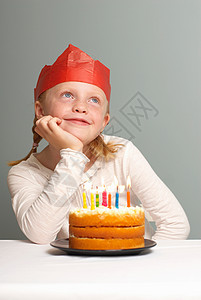坐在蛋糕前许愿的女孩图片