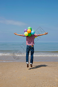 男人海滩跳跃气球图片
