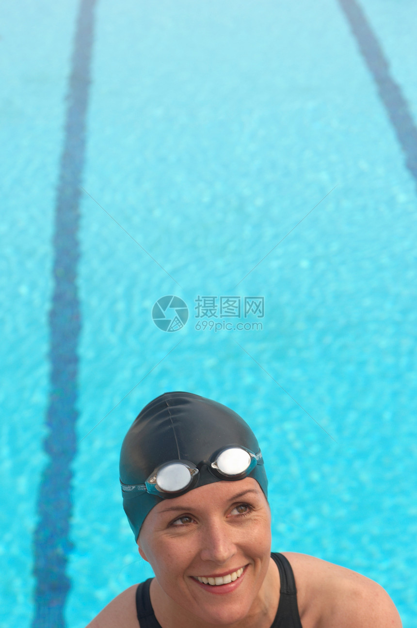 女性游泳运动员在泳池边微笑图片