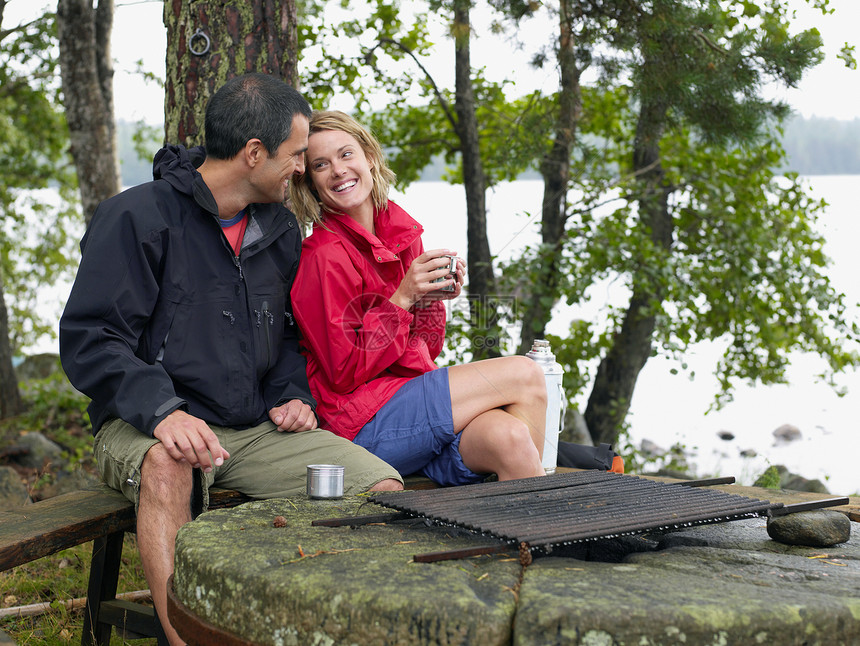 一对夫妇坐在靠近火坑的公园里图片
