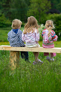 3个孩子坐在长椅上图片