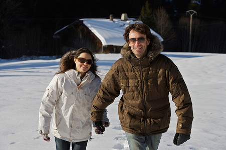一对在雪中行走的夫妇图片