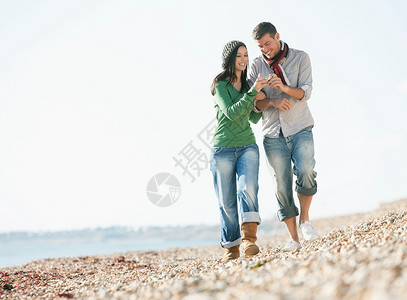 在海滩漫步的年轻夫妇图片