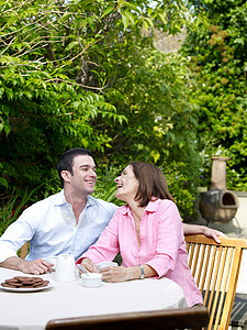 男人和女人坐在花园的桌子旁图片