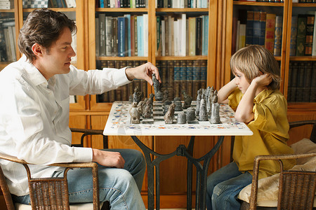 父亲和小男孩下棋图片