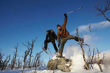 滑雪者在雪中从岩石上跳下图片