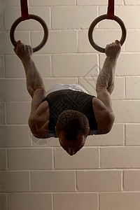 男子体操运动员在吊环上表演背景图片