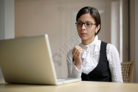 坐在笔记本电脑旁的商务女性图片