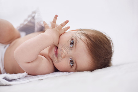 女婴仰卧吃手指高清图片