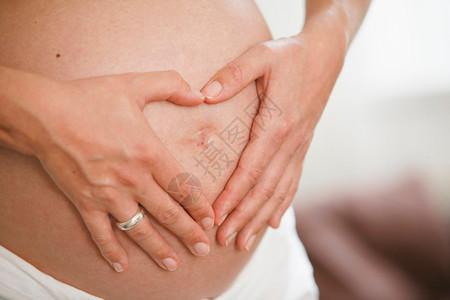 双手放在孕妇肚子上比心图片