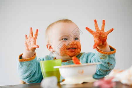 宝宝食物素材满手是番茄酱的婴儿背景