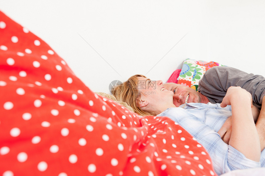 一对微笑的夫妇躺在床上图片
