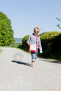 男孩赤脚在乡村公路上行走图片