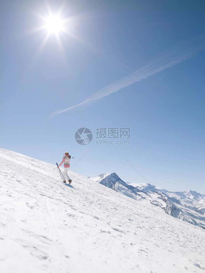 女人带着滑雪板上山图片