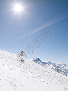 女人带着滑雪板上山图片