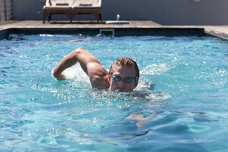 男人游泳戴护目镜的人在游泳池里游泳背景