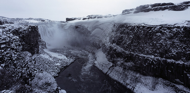 雪覆盖的悬崖上的瀑布图片