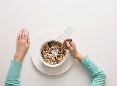 一个人的早餐手放在一碗谷类食品旁背景