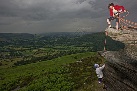 攀岩者攀登陡峭的岩石表面背景图片