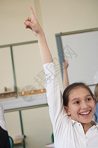 女孩在教室里举起手来校服高清图片素材