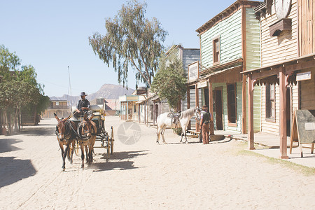 马和马车西班牙阿尔梅里亚塔伯纳斯布拉沃堡野生西部电影集上的牛仔和骡子车背景