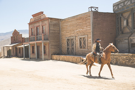 西班牙阿尔梅里亚，塔伯纳斯，布拉沃堡，野生西部电影集上的牛仔骑马图片