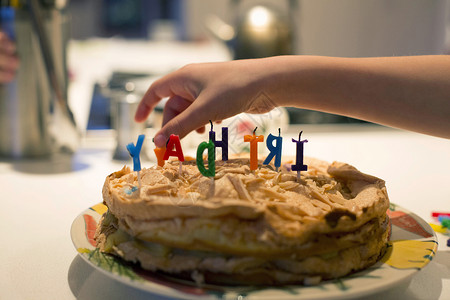 男孩的手从蛋糕上取下生日蜡烛图片