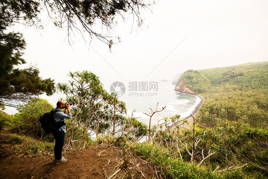 中年男子拍摄海岸线图片