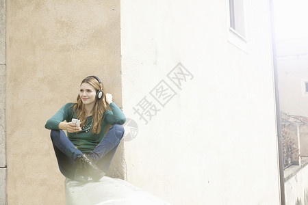 年轻女子盘腿坐着听音乐图片