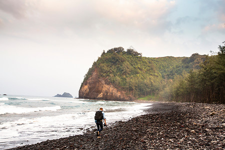 中年男子沿着海滩徒步旅行图片