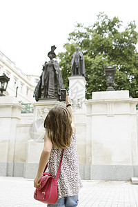 小女孩用手机拍太后雕像图片