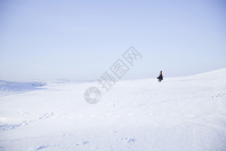 在雪景中行走的年轻女孩背景图片