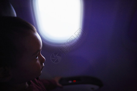 坐在飞机里的男孩背景图片