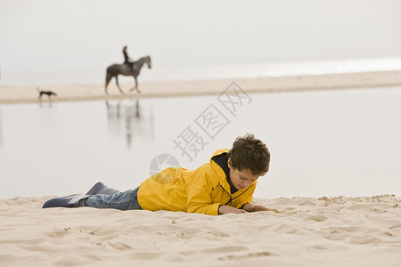 小男孩躺在沙滩上图片