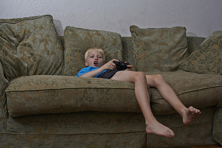 在客厅玩电子游戏的男孩图片