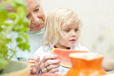曾孙女奶奶和孙女一起吃西瓜背景