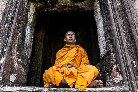 一个和尚挑水喝柬埔寨暹粒吴哥窟寺庙中的年轻和尚背景