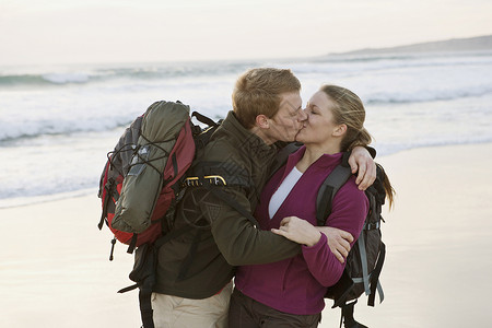背包情侣在海滩接吻图片