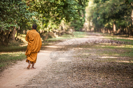 一个和尚挑水喝柬埔寨暹粒吴哥窟行走的年轻和尚背景