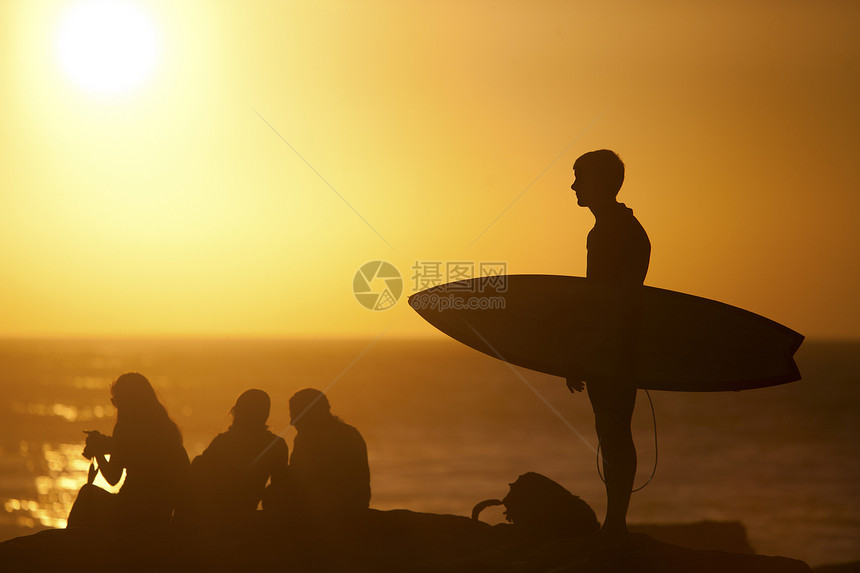 摩洛哥塔哈祖特日落海滩上的冲浪者携带冲浪板图片