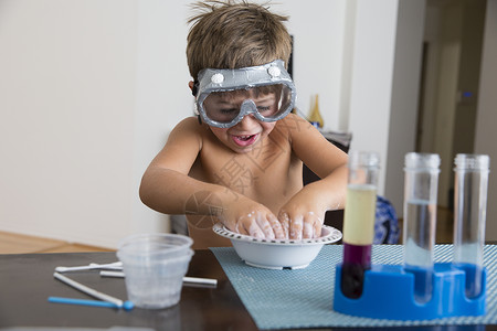 戴着护目镜的男孩在碗里玩混合物背景图片