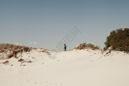 中年妇女站在美国纽约州琼斯海滩沙丘上图片