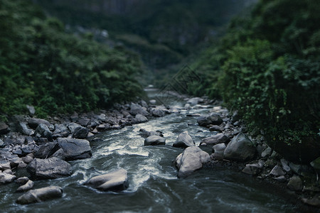 秘鲁圣谷Ollantaytambo岩石和树叶流淌的溪流景观图片