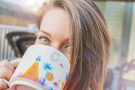 年轻女子从杯子里喝咖啡的特写镜头图片